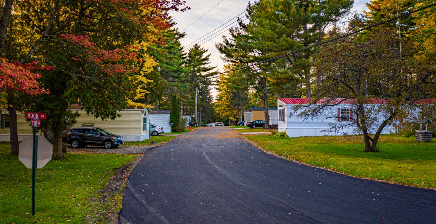 Curving road past homes and autumn foliage